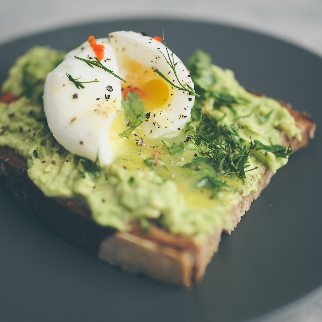 Smashed avocado with poached egg on a toasted farmhouse bread